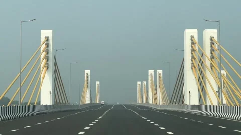 Multi-lane expressway bridge featuring a series of white structural towers and Stock Footage 325373886