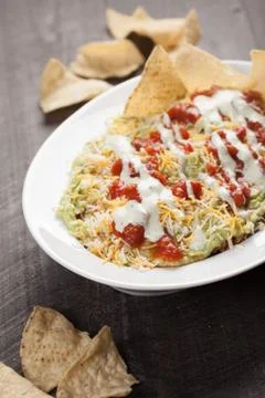 Multi-Layer Dip with Corn Tortilla Chips vertical shot Stock Photos