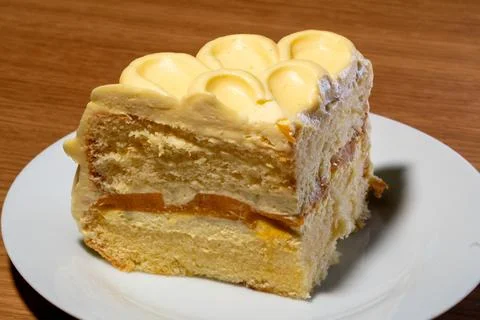 A multi-layered slice of delicious vanilla or mango cake with creamy yellow.. Stock Photos