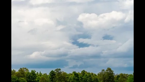 Multi layered strom clouds avove foliage of trees Stock Footage 329550271