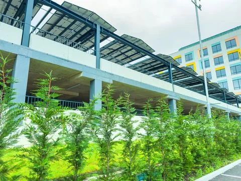 A multi-level building features solar panels on its roof. In the foreground,  Stockfoto's