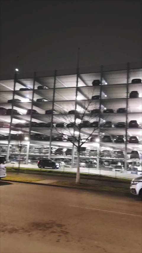 Multi-level parking with rows of cars inside a modern building at night Stock Footage 307378785