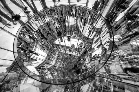 Multi-level reflections of people in mirrors inside a modern building with .. Fotos de archivo