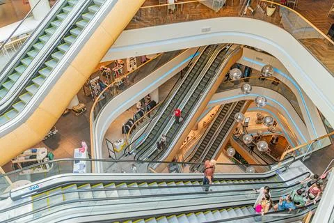 Multi-level retail space with curved glass staircases, polished surfaces re.. Stock Photos