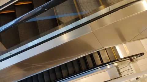 A multi-level view of an escalator with stainless steel and glass Video stock 304063097