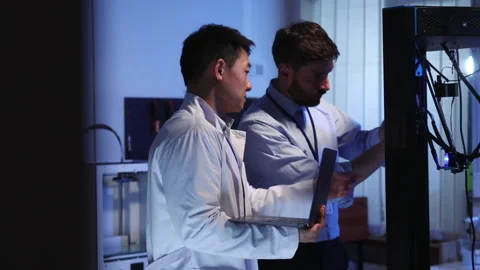 Multi-race asian and caucasian engineers working with electronic equipment Stock Footage 153744992