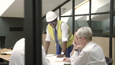 Multi race team of architects discuss project with african builder in modern Stock Footage 94772397