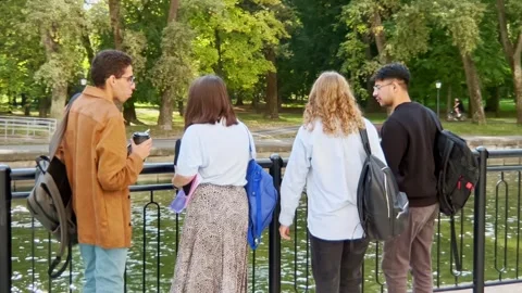 Multi racial classmates students with backpacks walk in park after their class Video stock 262467967
