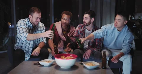 Multi-racial young men friends toasting drinking beer and cheering for football Stock Footage 148111017