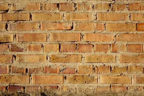 Multi-row masonry of light red bricks with vertical groove texture. Ugly mo.. Stock-Fotos