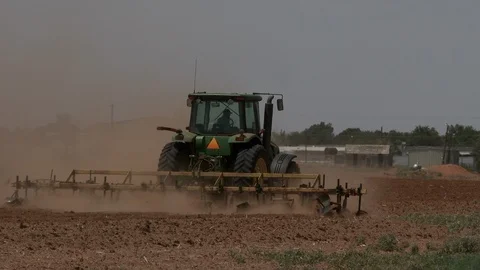 A multi row tractor plows a dusty field in spring planting, 4K. Stock Footage 100044500