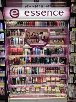 Multi-shelf display stand filled with Essence brand cosmetics. Stock Photos