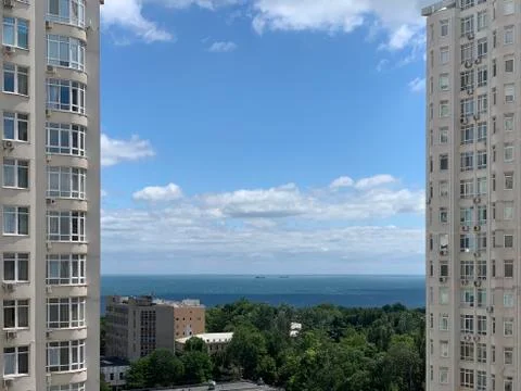 Multi-storey building against the backdrop of the sea and blue sky. Tall new  Stock Photos
