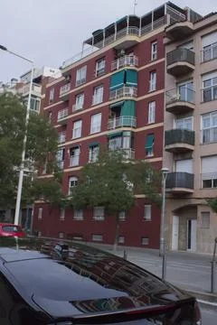 Multi-storey building with red facade walls, near the road Stock Photos