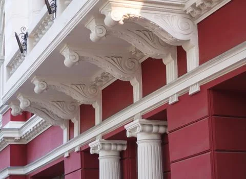 Multi-storey building with the red wall which is  decorated with beautiful wh Stock Photos