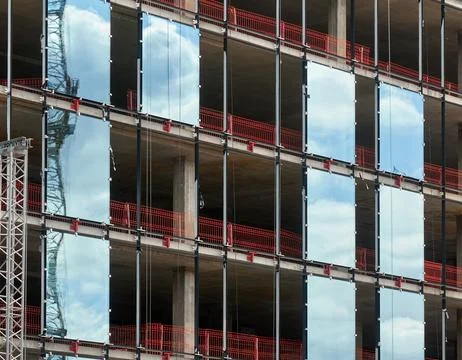 Multi-storey building under construction with scaffolding and blue sky Stock Photos