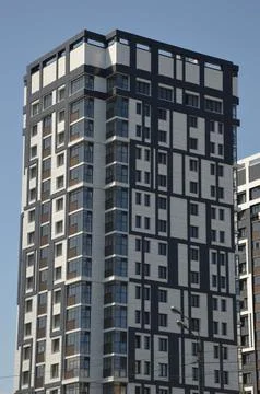 A multi-storey gray building standing against a blue sky. Modern high-rise .. Foto stock