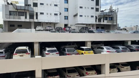 Multi storey parking lot, many cars parking outdoor daytime panning, Bangkok Stock Footage 250378404