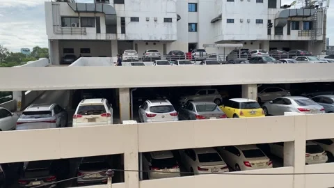 Multi storey parking lot, many cars parking outdoor daytime tilt down, Bangkok Stock Footage 250378411