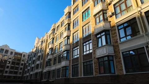 Multi-storey residential building half lit by the sun 스톡 동영상 197549848