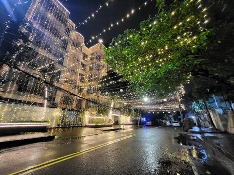 A multi-story building adorned with strings of golden fairy lights. Fotos Stock