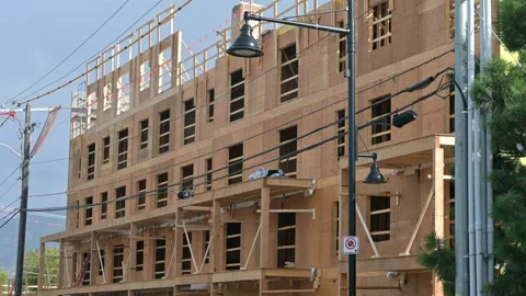 Multi story building under construction with wood framing under a blue sky Stock Footage 346869429