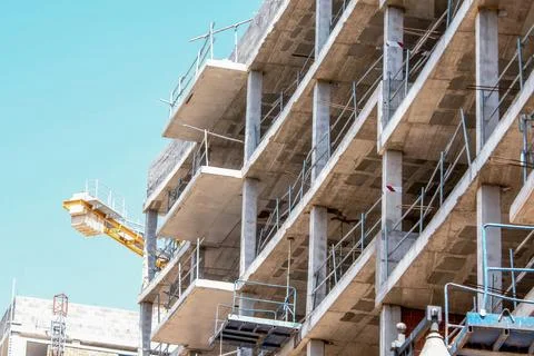 Multi-story building under construction with concrete floors, support columns Stock Photos