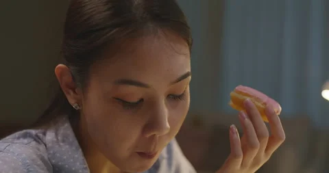 Multi-tasing busy worker overnight crave sweet donut for night meal. 스톡 동영상 173699275
