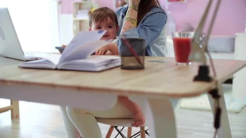 Multi tasking mother with son working a home  Stock Footage 75365956