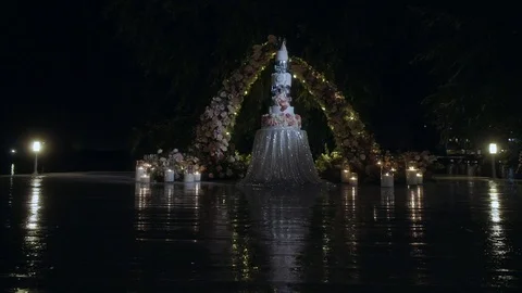 Multi-tiered cake with the bride and groom at the top. decorated with a crystal  Stock Footage 124247428