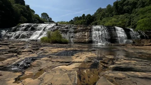 Multi-Tiered Waterfall Cascading Over Rocky Terrain in Forest, Wide Static Shot Stock Footage 324770573