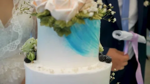 Multi-tiered wedding cake made of mastic decorated with cream roses and flowers Video stock 299917233