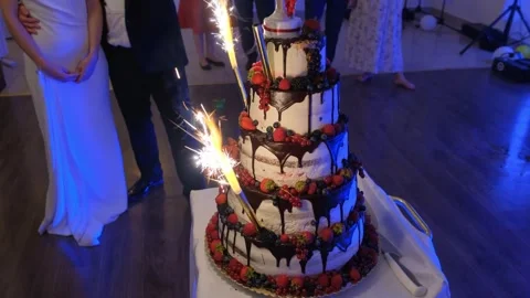 Multi-tiered wedding cake with sparklers lighting in event hall Video stock 342018626