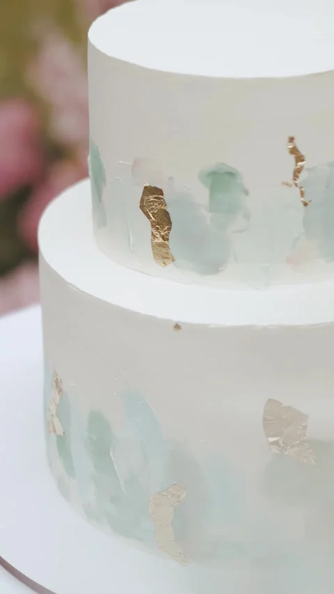 Multi-tiered white wedding cake with beautiful floral ornament. Cake near the Video stock 307922224