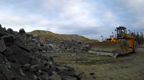 Multi-ton bulldozer on wheels raises the bucket and rides. Close-up. Video stock 55284524