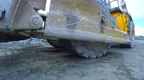 Multi-ton bulldozer on wheels raises the bucket and rides. Close-up. Video stock 55284775