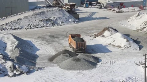 A multi-ton dump truck dumps rubble on the ground in winter. Stock Footage 122213130