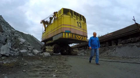Multi-ton tracked excavator loading railway cars in iron ore. Nearby is working. Video stock 55284614