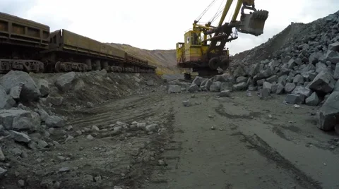 Multi-ton tracked excavator loading railway cars in iron ore Video stock 55858343