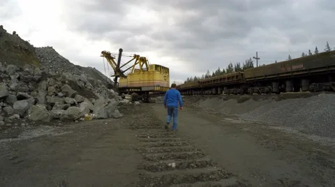 Multi-ton tracked excavator loading railway cars in iron ore. Video stock 56573754