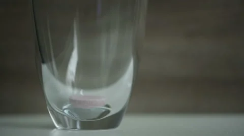 Multi-vitamin effervescent tablet dissolves inside a cup of water. Stock Footage 68499227