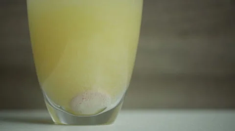 Multi-vitamin effervescent tablet dissolves inside a cup of water. Stock Footage 68499241