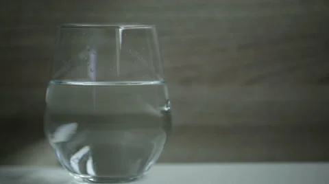 Multi-vitamin effervescent tablet dissolves inside a cup of water. Stock Footage 68499246