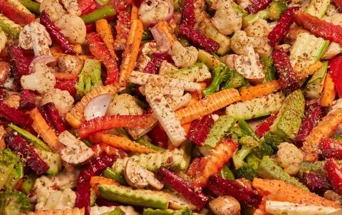 Multicolor background of sliced vegetables with dried spices. Stock Photos