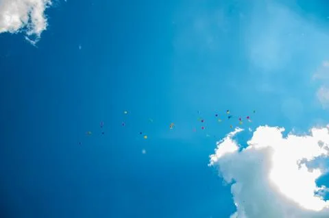 Multicolor ballons in the summer blue sky with clouds. Stock Photos