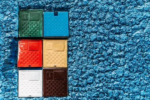 Multicolor boxes on blue wall: A lively fusion of colors, these vibrant box.. Stock Photos
