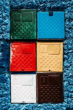 Multicolor boxes on blue wall: A lively fusion of colors, these vibrant box.. Stock Photos