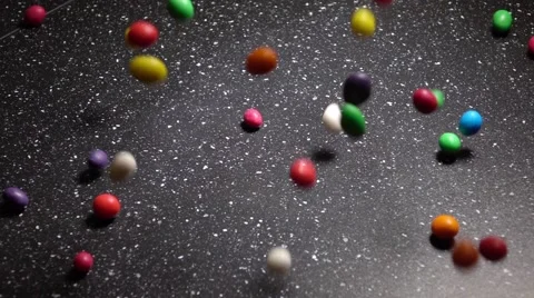 Multicolor Candy Falling Down on Black Table Stock Footage 63147116