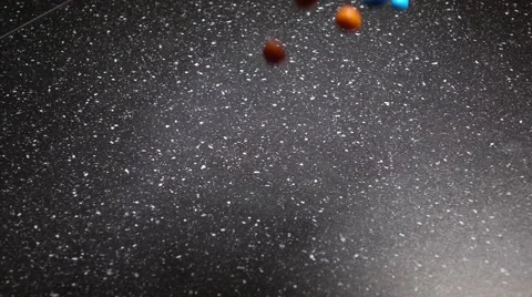 Multicolor Candy Falling Down on Black Table Stock Footage 63147159
