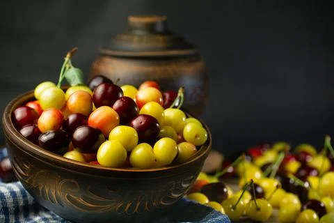 Multicolor cherries in the plate Stock Photos